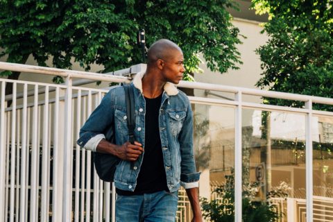 portrait-african-young-man-with-his-backpack-shoulder-looking-away